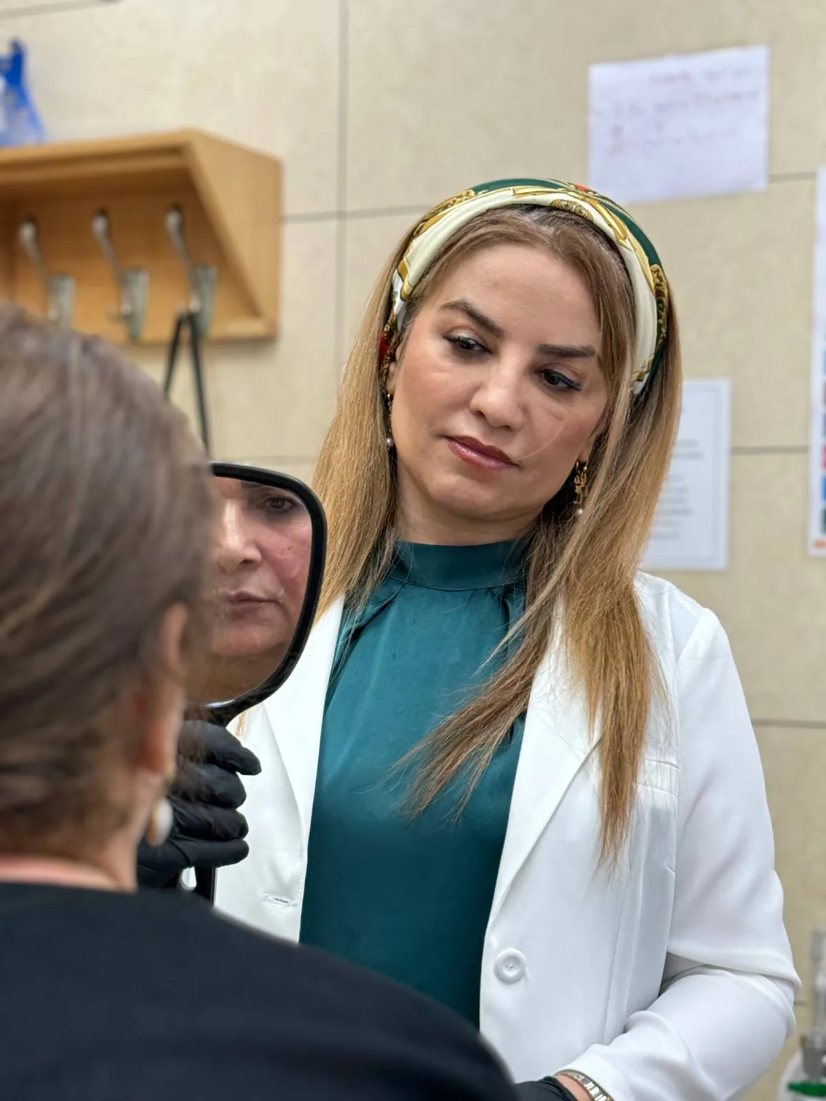 دکتر شادی مظلومی در حال ارزیابی چهره مراجعه‌کننده با آینه در جلسه مشاوره